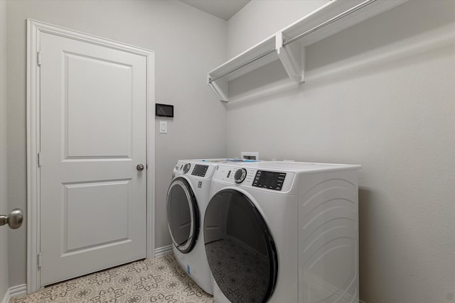 laundry area with separate washer and dryer and light tile patterned floors