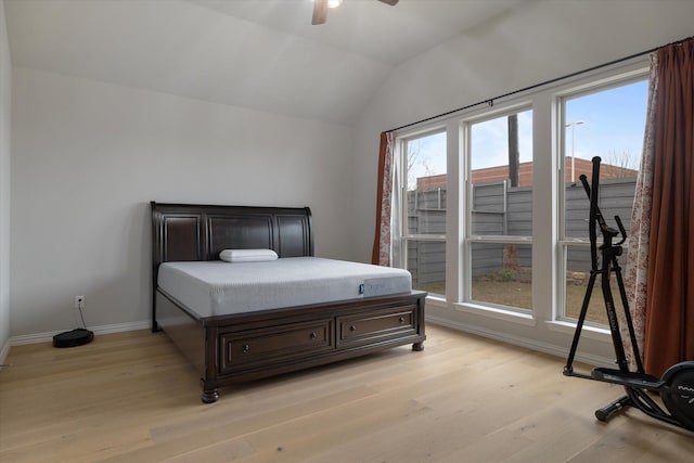 bedroom with multiple windows, light hardwood / wood-style floors, vaulted ceiling, and ceiling fan