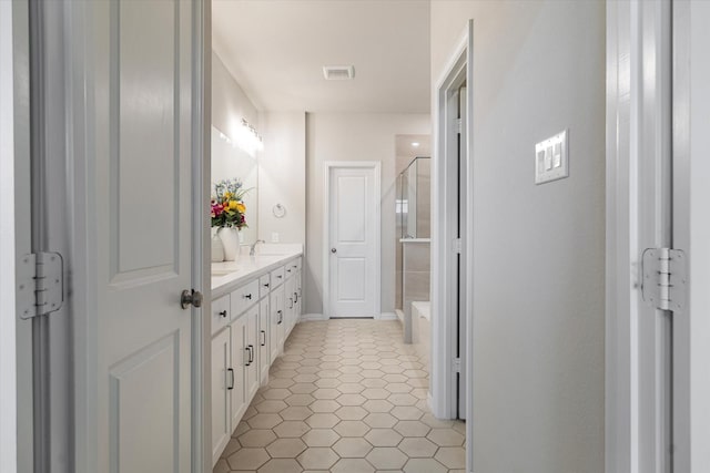 bathroom with tile patterned floors, vanity, and an enclosed shower