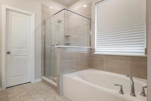 bathroom featuring tile patterned floors and shower with separate bathtub