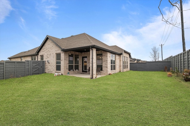 rear view of property with a lawn and a patio area