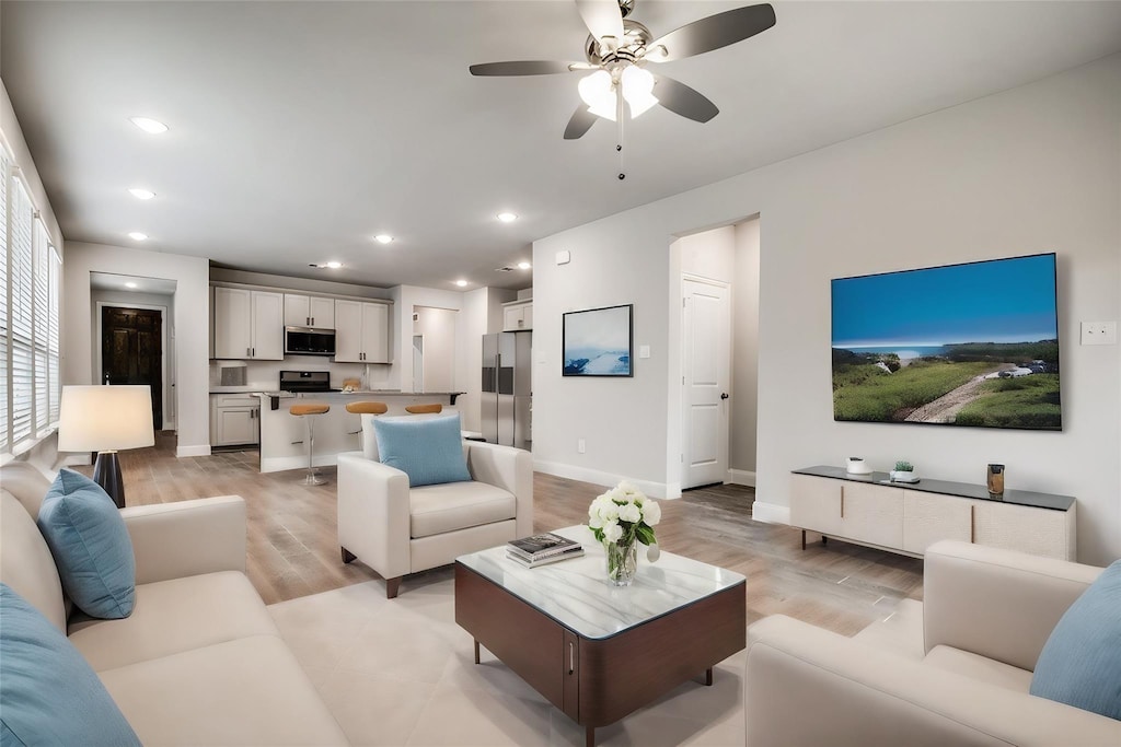 living room featuring ceiling fan and light hardwood / wood-style flooring