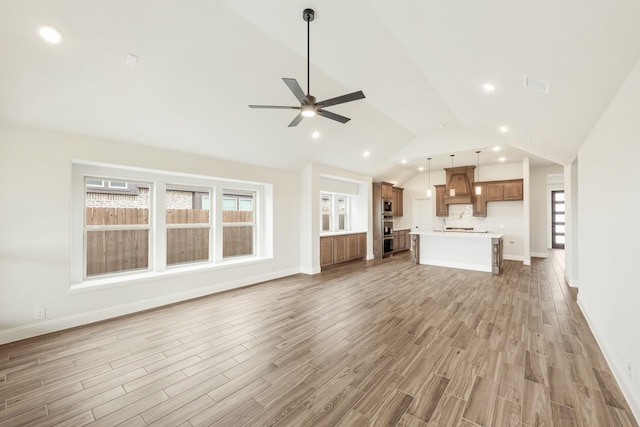 unfurnished living room with recessed lighting, vaulted ceiling, visible vents, a ceiling fan, and light wood-style flooring