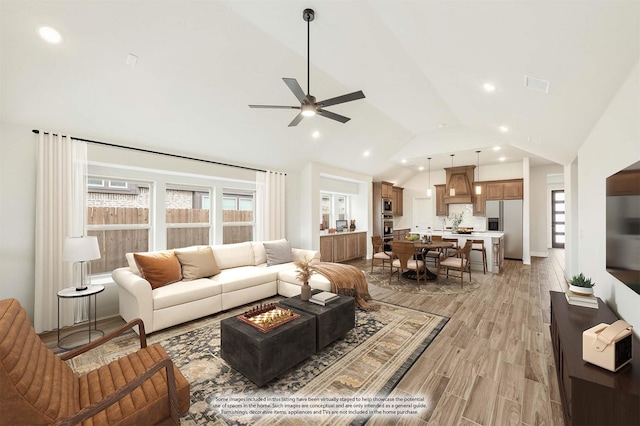 living area featuring lofted ceiling, a ceiling fan, visible vents, and recessed lighting