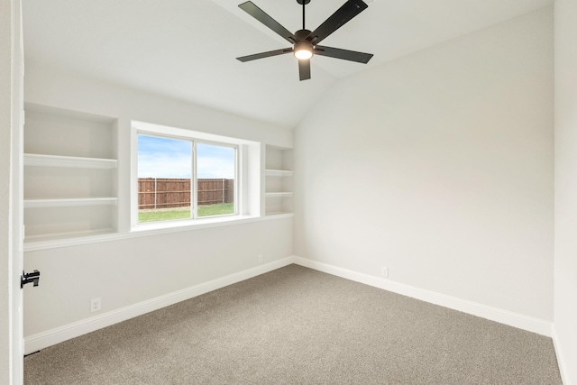 unfurnished room featuring a ceiling fan, built in features, baseboards, lofted ceiling, and carpet flooring