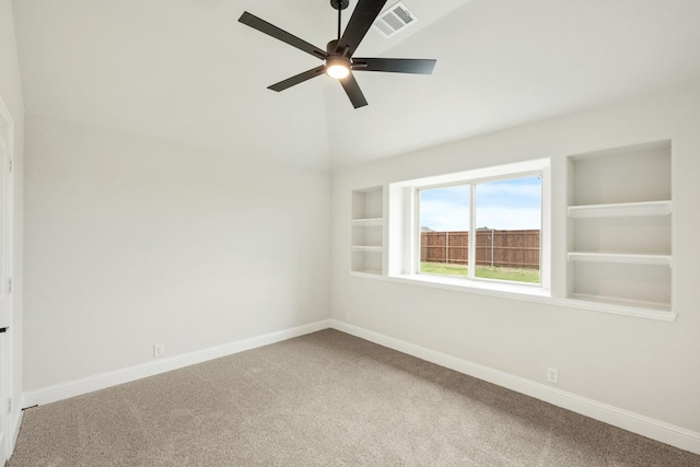 empty room featuring a ceiling fan, baseboards, lofted ceiling, carpet flooring, and visible vents