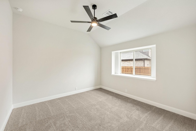carpeted empty room featuring lofted ceiling, baseboards, ceiling fan, and visible vents
