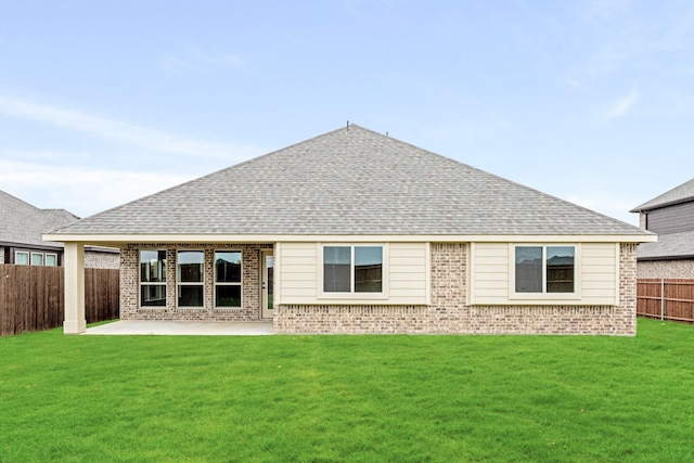 back of property with brick siding, a patio area, roof with shingles, and fence