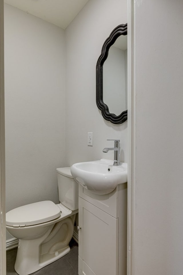 bathroom with tile patterned flooring, vanity, and toilet