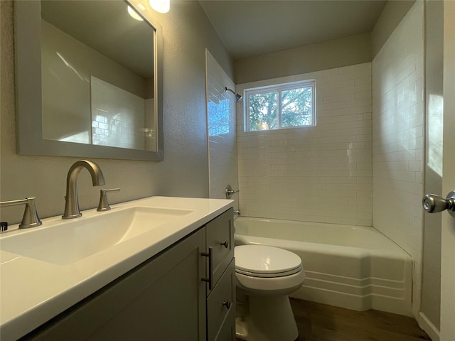 full bathroom with wood-type flooring, vanity, toilet, and tiled shower / bath combo