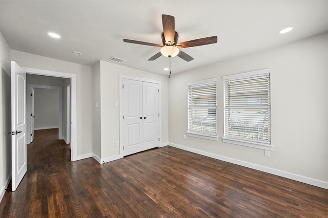 unfurnished bedroom with ceiling fan, dark hardwood / wood-style floors, and a closet