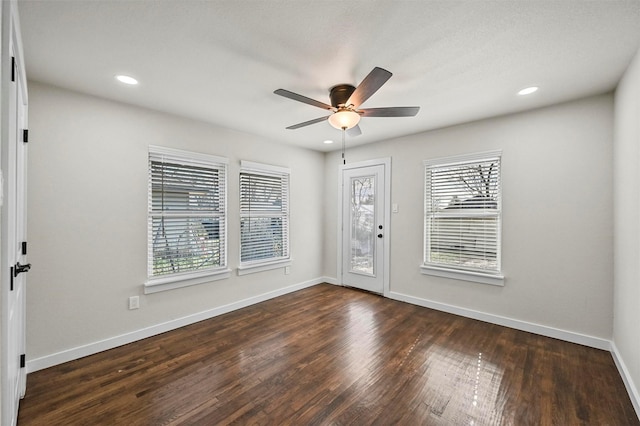 foyer entrance with ceiling fan and dark wood-type flooring