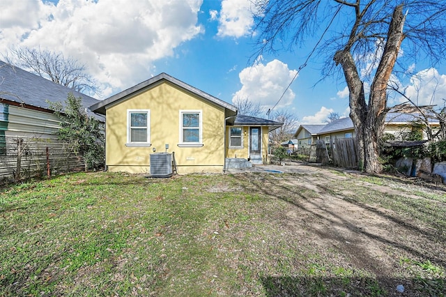 rear view of property with a yard and central AC unit