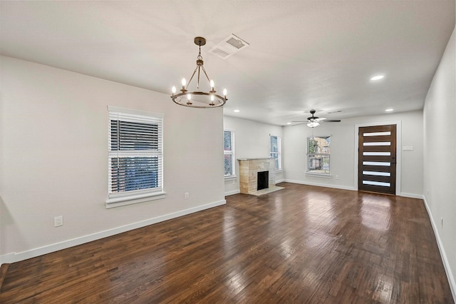 unfurnished living room with dark hardwood / wood-style flooring and ceiling fan with notable chandelier