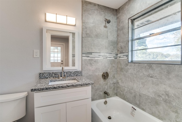 full bathroom with vanity, tiled shower / bath combo, and toilet