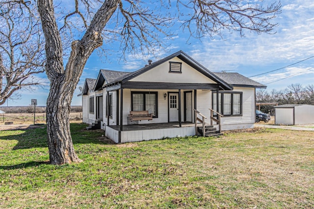 view of front facade with a storage unit, covered porch, and a front yard