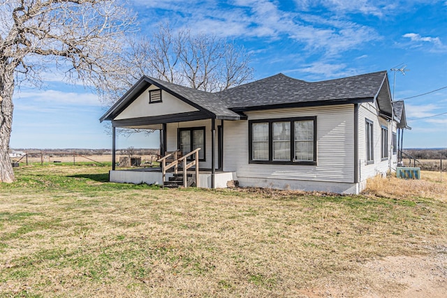 view of front of house with central AC unit, covered porch, and a front lawn