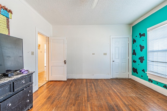 bedroom with a textured ceiling, dark hardwood / wood-style floors, and multiple windows