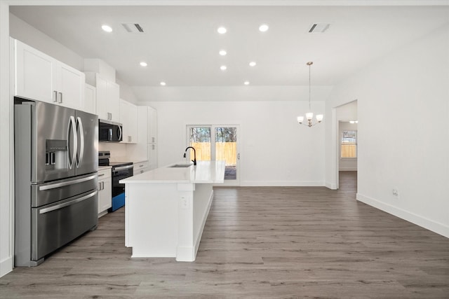 kitchen with stainless steel appliances, sink, pendant lighting, a center island with sink, and white cabinets