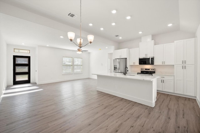 kitchen with stainless steel appliances, sink, a center island with sink, white cabinets, and hanging light fixtures