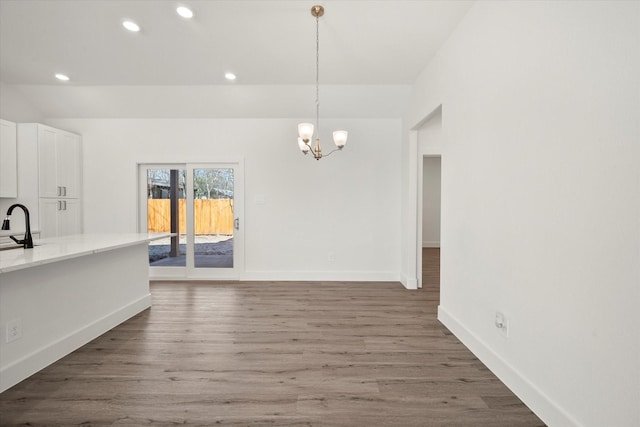 unfurnished dining area with dark hardwood / wood-style floors, a notable chandelier, and sink