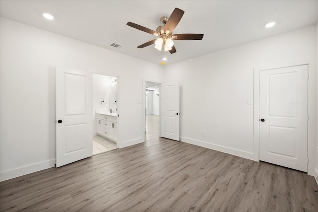 unfurnished bedroom with ensuite bathroom, light hardwood / wood-style flooring, and ceiling fan