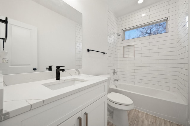 full bathroom featuring vanity, toilet, and tiled shower / bath