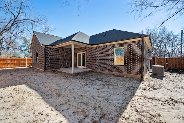 rear view of house with central air condition unit and a patio