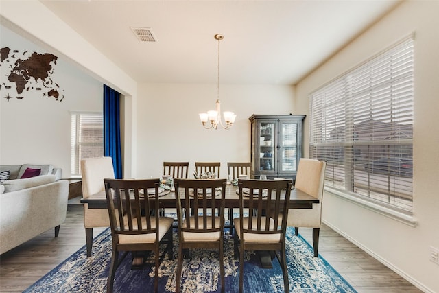 dining room with dark wood-type flooring and a notable chandelier