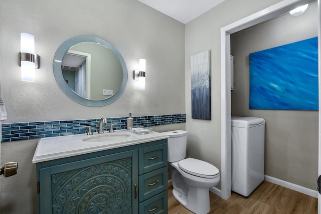 bathroom featuring backsplash, hardwood / wood-style floors, vanity, and toilet