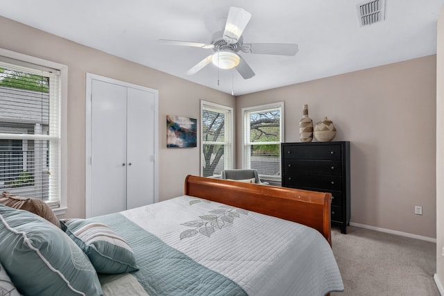 carpeted bedroom with ceiling fan and a closet