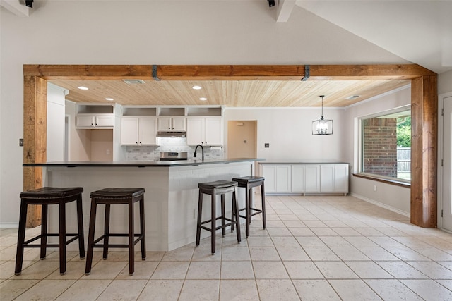 kitchen with pendant lighting, wooden ceiling, white cabinets, a kitchen breakfast bar, and decorative backsplash