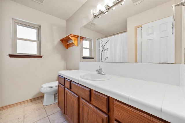 bathroom with vanity, curtained shower, and toilet