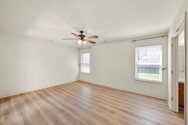 spare room featuring plenty of natural light, ceiling fan, and light wood-type flooring