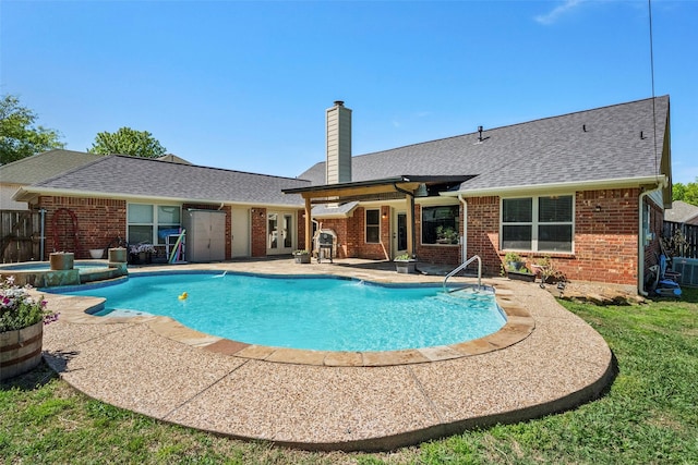 view of swimming pool with a patio area and an in ground hot tub