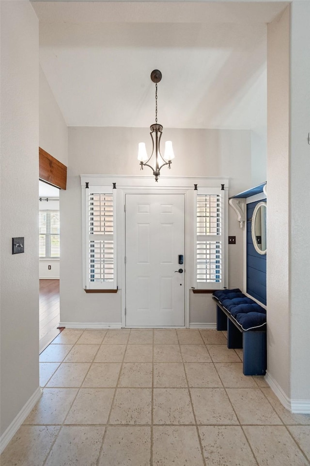 foyer entrance with vaulted ceiling and an inviting chandelier