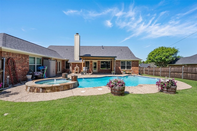 view of swimming pool with an in ground hot tub, a yard, and a patio