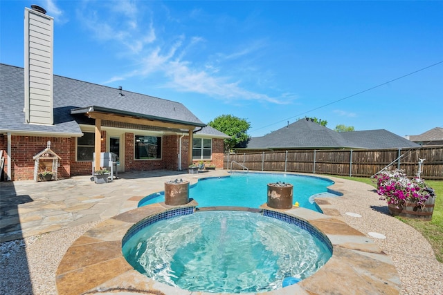 view of pool with an in ground hot tub and a patio