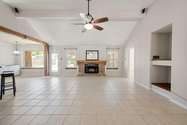 living room featuring light tile patterned floors, ceiling fan with notable chandelier, a brick fireplace, and plenty of natural light