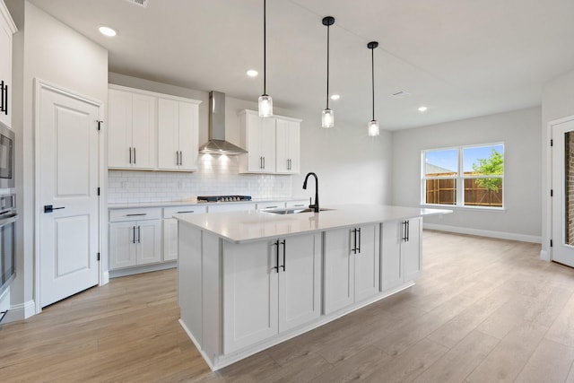 209 Briarwood Dr, Nevada, TX 75173 - kitchen featuring wall chimney exhaust hood, stainless steel appliances, light wood-type flooring, light countertops, and recessed lighting