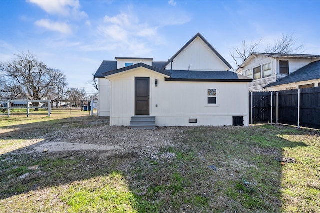 rear view of property with a lawn and central AC