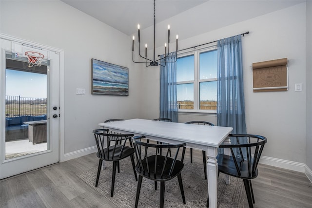 dining area with hardwood / wood-style floors and a chandelier