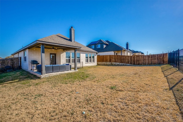 back of property featuring a patio area, ceiling fan, a yard, and an outdoor living space