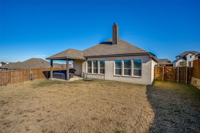 back of property with a lawn and a patio