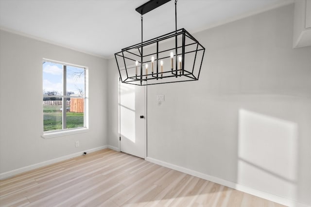 unfurnished dining area with a chandelier and light wood-type flooring