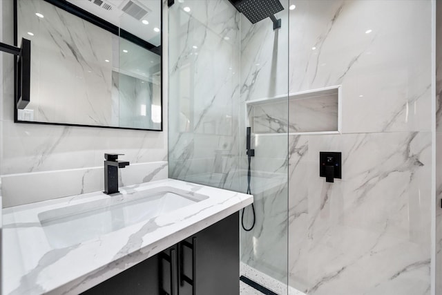 bathroom with vanity and a tile shower