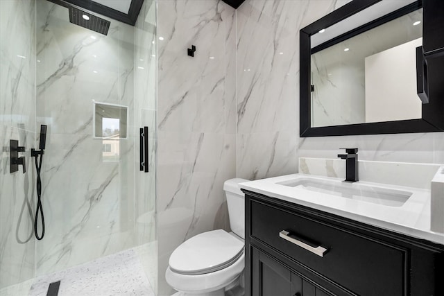 bathroom featuring vanity, toilet, a shower with shower door, and tile walls