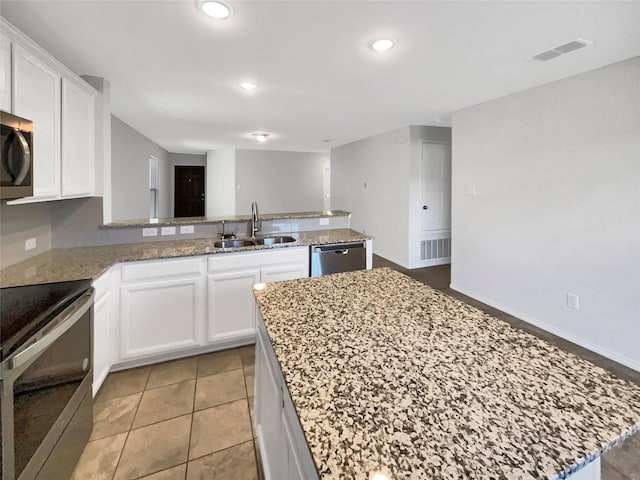 kitchen featuring a center island, white cabinetry, sink, and appliances with stainless steel finishes