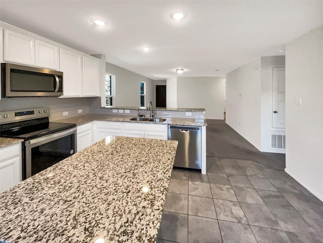 kitchen with white cabinets, stainless steel appliances, light stone countertops, and sink