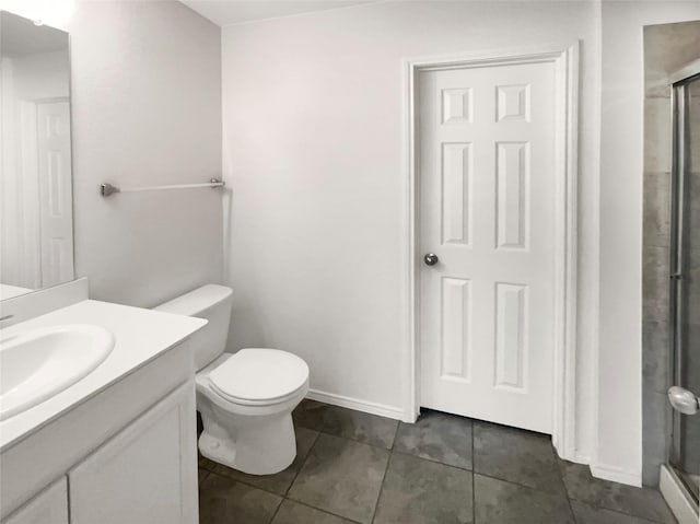 bathroom with tile patterned floors, toilet, vanity, and walk in shower